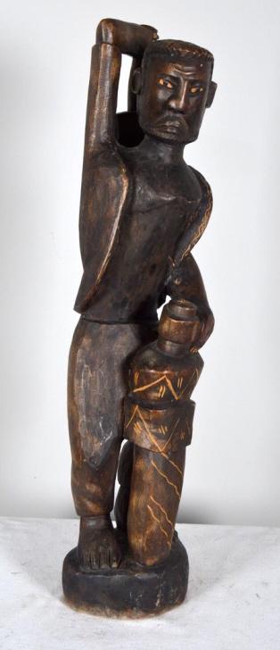 Central African Warrior Sculpture: 20th Century, wood; of a standing male with sword and scabbard to the front and mallet behind head. 32 x 7 x 6 in. Condition: Wear consistent with age and use Property of Anthony French. Sr.