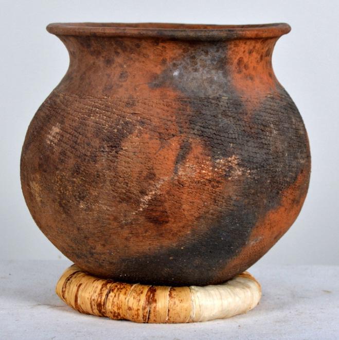 Early 20th Century East African Clay Pot: Of globe form, incised body and resting on a woven rush ring. 9 x 9 in. Condition: Wear consistent with age and use Property of Anthony French. Sr.