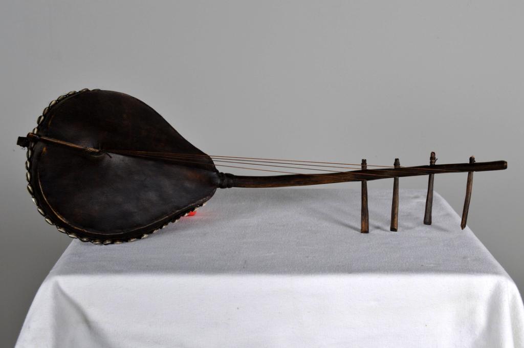 Vintage West African Kora: With a gourd body embellished with cowrie shells, four strings. 25 x 8 x 5 in. Condition: Wear consistent with age and use Property of Anthony French. Sr.