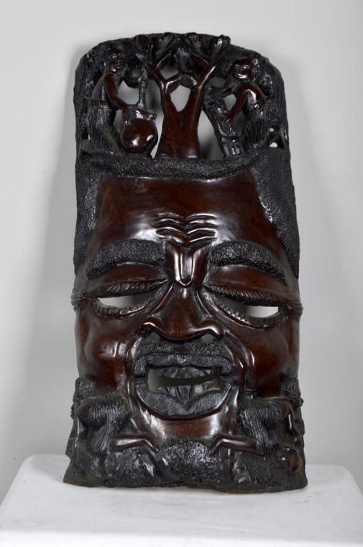 Modern African Sculptural Mask: Of a man with headdress of people tending to a tree, beneath his face two women tend to fields. 29 x 15 x 6 in. Condition: Wear consistent with age and use Property of Anthony French. Sr.