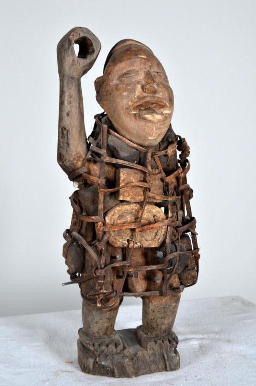 Songye Nail Fetish Figure: 20th Century, Bantu, Songye, Zaire; wood male figure with nails, wearing a loosely woven coat of leather stripping. 17 x 6.5 x 4 in. Condition: Wear consistent with age and use Property of Anthony Fre