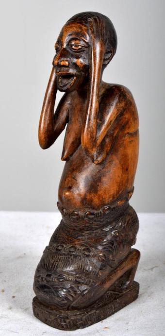 West African Maternity Sculpture: Africa , Western , Wood; Woman kneeling and putting both arms on her head 9 x 3.5 x 2 in Condition: Wear consistent with age and use Property of Anthony French. Sr.