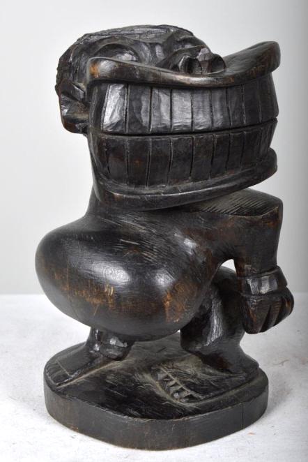 Western African Statue: Western African , wood ; The hand carved statue of a man with exaggerated teeth and large stomach 10 x 5 x 5 in. Condition: Wear consistent with age and use Property of Anthony French. Sr.