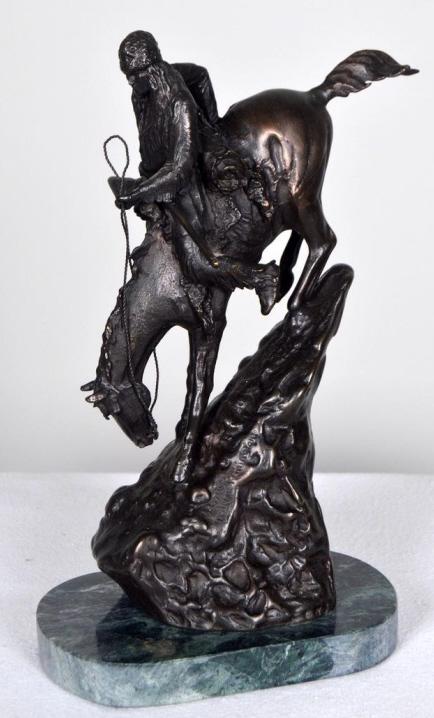 After Frederic Remington (American, 1861-1909): Mountain man Bronze cast The mountain man has a gun and is holding on to the horse as he is descending down Signed Frederic Remington in the bronze 10 x 6 x 4 in. br> Condition: No apparent flaws Prop