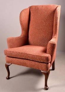 Queen Anne Style Wingback Armchair: With over upholstered back, wings and seat, the whole raised on two cabriole legs ending in pad feet to the front and two splayed square legs to the rear. 47 x 33 x 26 in. NOTE: NO apparent