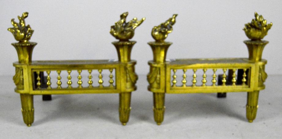 Pair of Louis XVI Chenets: Each with a pair of flame finials over a post with drapery and a tapered round leg in the form of acanthus leaves. 12 x 12 x 11 in.