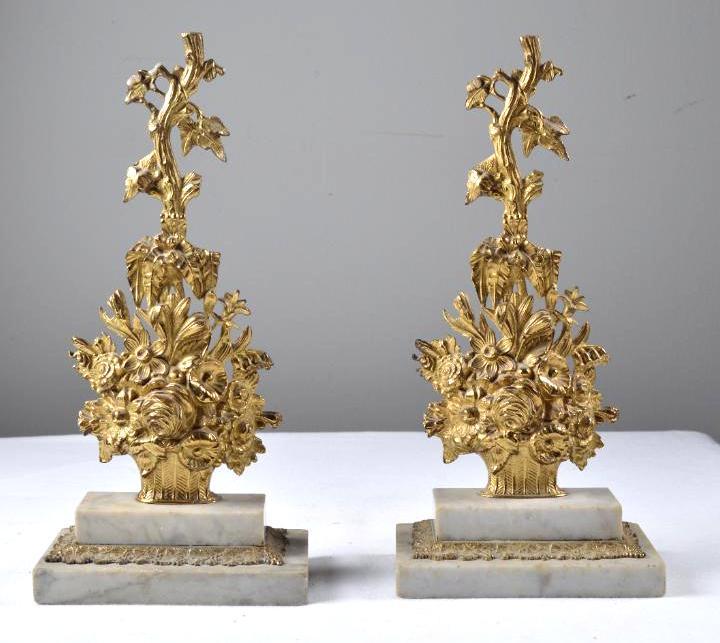 Brass Garniture Set: Each of a basket of flowers is raised on a rectangular stepped marble base. Label "Dietz Brothers & Co." 14 x 6.5 x 4 in.