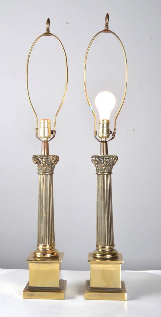 Pair of Brass Corinthian Column Lamps: Classic greek scroll design on top of corinthian column on brass base Dimensions: 33 x 5.5 x 5.5 in. NOTE: Tested, working; Wear consistent with age and use