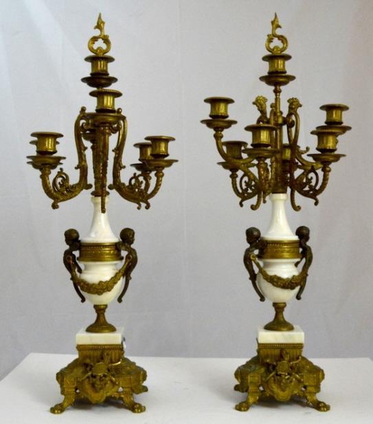 Pair of Brevatatto Seven Light Candelabra: Marked Brevatatto on base. Each with a central capital over six capitals emanating from a central, cherub mounted urn, the whole raised on an orate plinth. 27 x 10 in.
