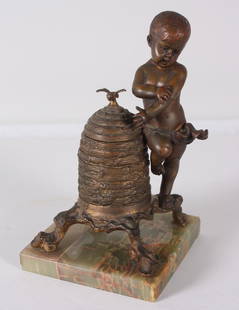 20th C. Bronze Inkwell: Desk top inkwell of boy alongside a wicker motif inkwell on green marble base. Inkwell contains a small Seger porcelain ink holder. Dimensions: H 7.5 x W 4.5 x D 4.5 inches NOTE: Wear consistent