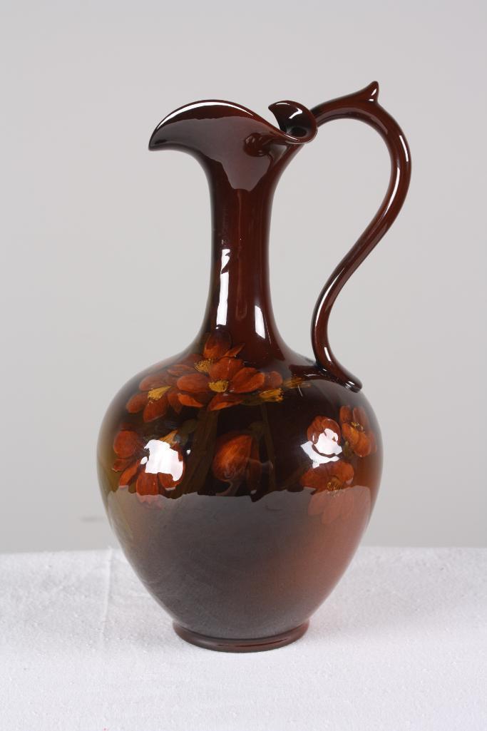 Rookwood Pottery Ewer (Elizabeth "Lizzie" N Lincoln): Dated 1902, with a brown ground and poppies, marked on base. Dimensions: H 10.5 x W 6 x D 6 inches NOTE: No evidence of cracks, chips or repairs