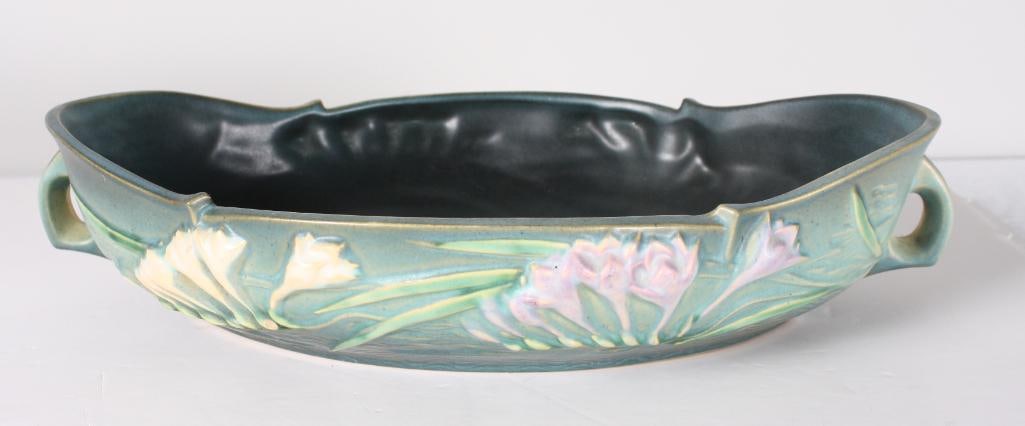 Roseville Pottery Freesia Center Bowl: The handled bowl has white and purple freesia on green ground. 469-16 marked on base Dimensions: H 3.75 x W 16 x D 9.75 inches NOTE: No apparent chips, cracks or repairs