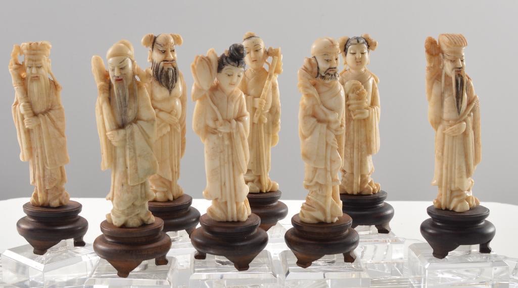 Eight (8) Japanese Bone Immortals: Of the eight immortals, each on a fitted base. Glass tray not included. Dimensions: H 4.5 x W 0.75 x D 0.75 inches NOTE: Good condition given age and use