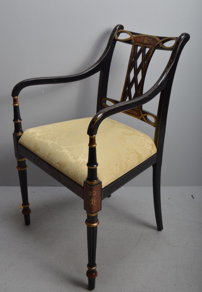 Directoire Ebonized and Gilt Armchair: WIth a pierced crestrail over gilt splat, teh upholstered seat flanked by shaped arms and turned stumps, raised on turned legs Dimensions: H 35 x W 21 x D 17 inches NOTE: Wear consistent with age and 