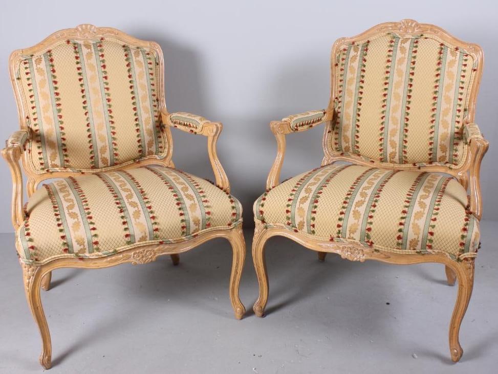 Pair of Louis XV Style Fateuils: Each painted and "antiqued" in yellow, with a carved crestrail over an upholstered back with carved rails, the upholstered seat flanked by two pad upholstered arms with carved and shaped stump