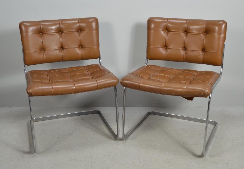 Pair of Mid Century Side Chairs: With a plain tufted back, in the manner of Robert HaussmannDimensions: H 28.5 x W 21.5 x D 20 inchesNOTE: Some wear to the leather