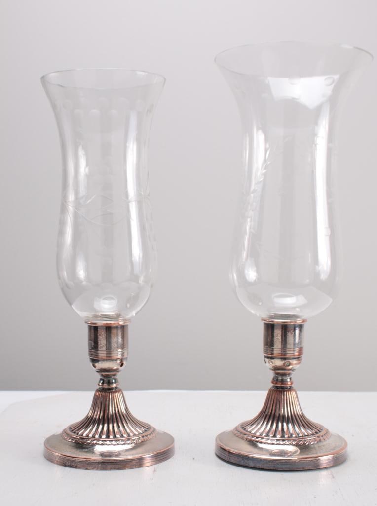 Near Pair of Silverplate and Etched Glass Hurricane Lamps: Each base with a plain capital over a gadrooned round base, one Hurricane original, the other a near match. Unmarked Dimensions: H 16 x W 5.5 x D 5.5 inches NOTE: Wear consistent with age and use