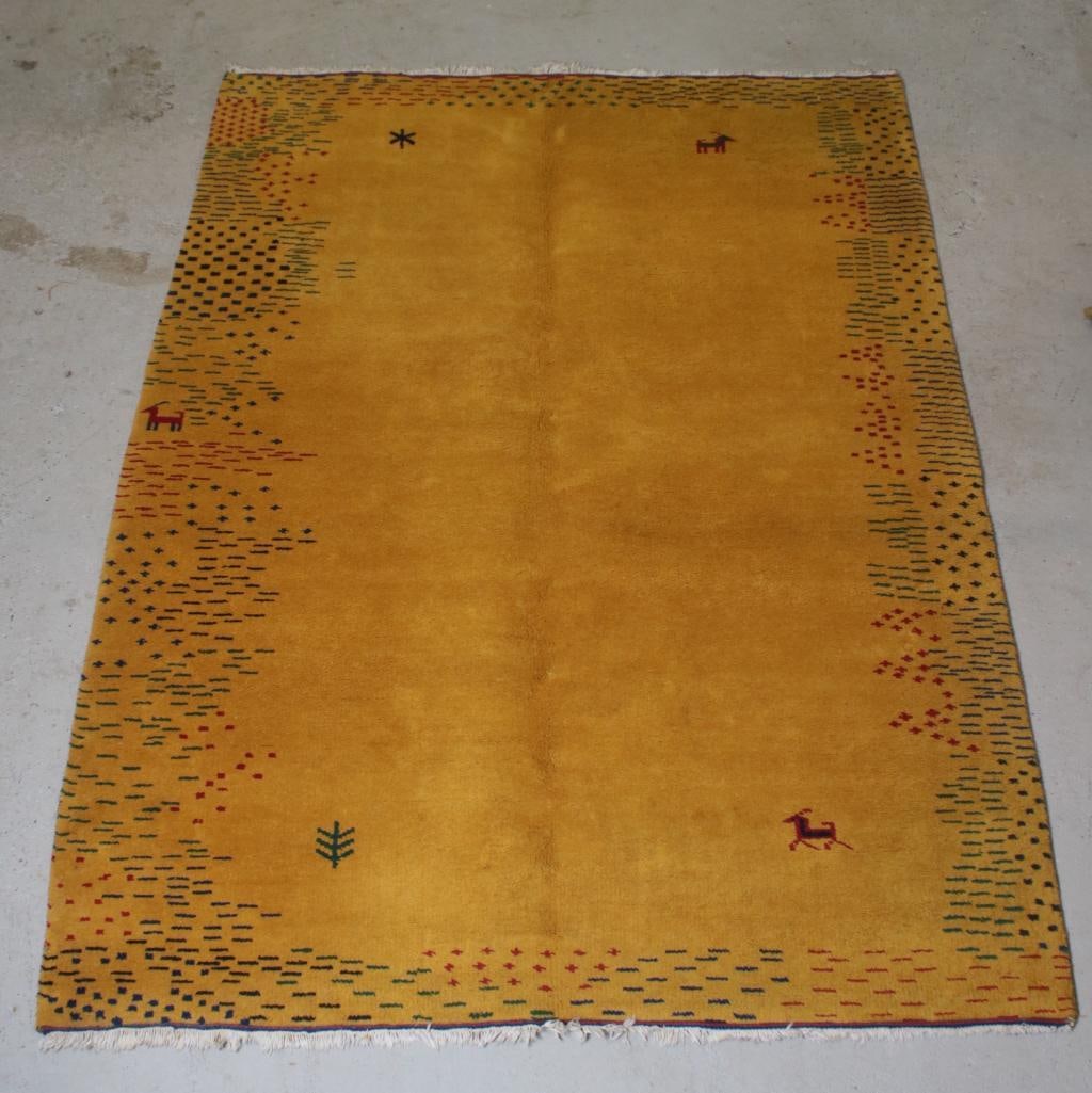 Tribal 7' 11" X 5' 6" Gabbeh Rug: Hand woven wool. Yellow ground with deer Dimensions: H 1 x W 95 x D 67 inches NOTE: Good Condition