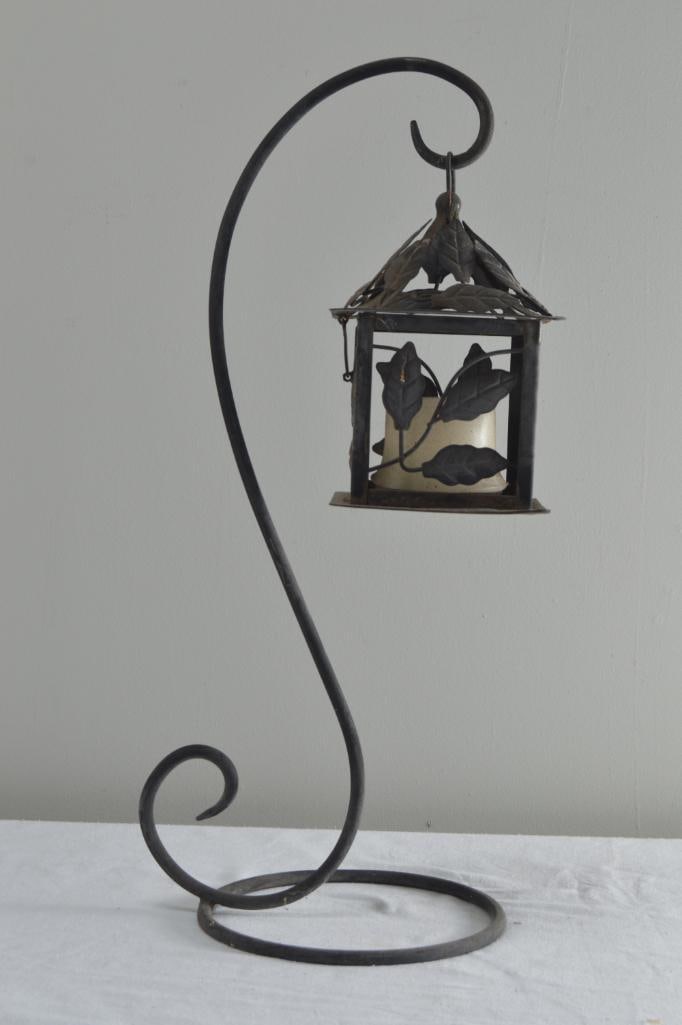 Outdoor Votive Hanger and Votive: With a lantern of ivy leaves, hanging from a shaped metal stand Dimensions: H 24 x W 8.5 x D 8.5 inches NOTE: Good condition Property from an Anchorage, KY home