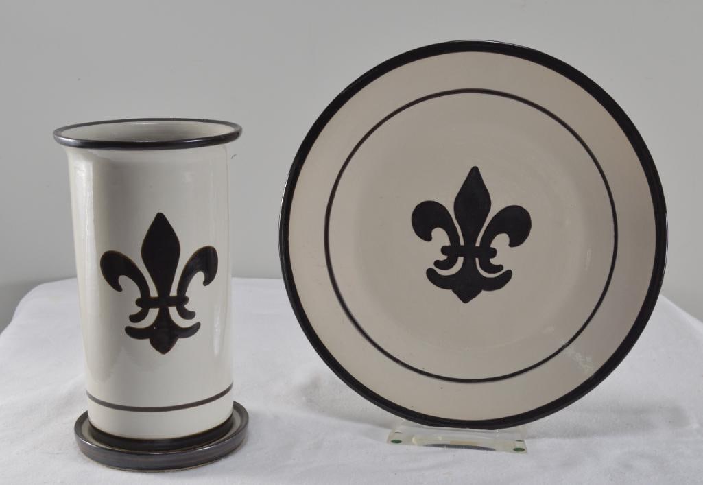 Two Pieces of Louisville Stoneware in Fleur de Lis Pattern: A tall vase with a saucer and a large plate, Plate is 13.5 in Diameter, measurements for vaseDimensions: H 11 x W 6 x D 6 inchesNOTE: Very good condition, no evidence of chips or flawsProperty from an
