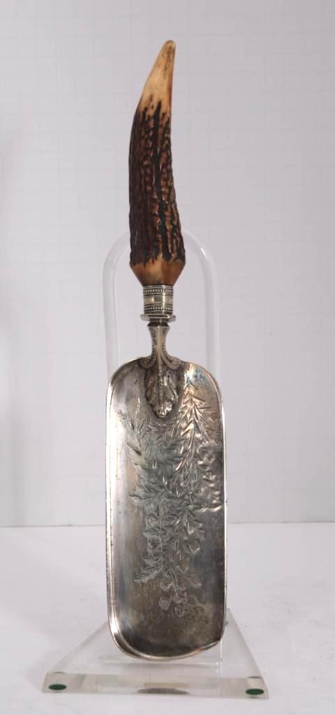 Silverplate Table Crumber with Horn Handle: With chased silverplate body and faux horn handle Dimensions: H 1 x W 13 x D 2.5 inches NOTE: Good Condition