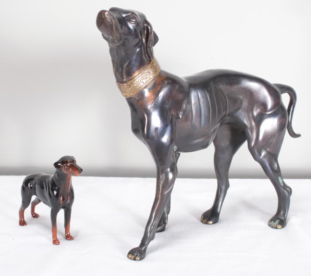 Pair of Dog Sculptures: Larger one is bronze, smaller is porcelain by Beswick. Dimensions for largest dog Dimensions: H 15 x W 18 x D 14 inches NOTE: Wear consitent with age and use