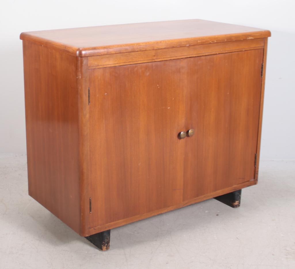A Walnut Mid Century Console: With a moulded rectangular top over two doors, raised on peg feet Dimensions: H 29 x W 35 x D 17 inches NOTE: Wear consistent with age and use