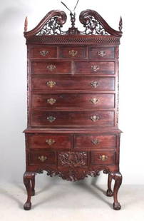 George III Style Chest on Stand: Mid 20th C. Two piece, Broken carved and pierced pediment with lattice carving top with with eight drawers and batwing brass pulls. The lower part with four carved drawers, raised on carved ball and
