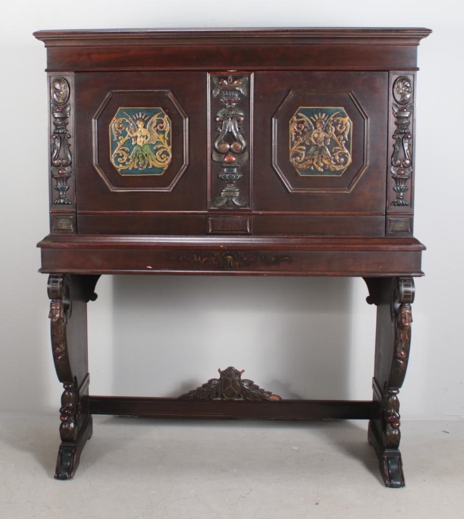 Spanish Colonial Style Secretary: WIth a square top over a drop down writing surface adorned with lozenges of mythical beings opening to reveal twelve cubbies and two drawers, raised on carved plank legs supported by a stretcher. Bear