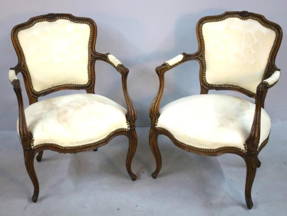 Pair of Louis XV Style Fauteuil: Mid 20th C. Upholstered, with rocaille and floral carving, cabriole legs ending in scrolled feet. Dimensions: H 32 x W 22 x D 22 inches NOTE: Staining to fabric