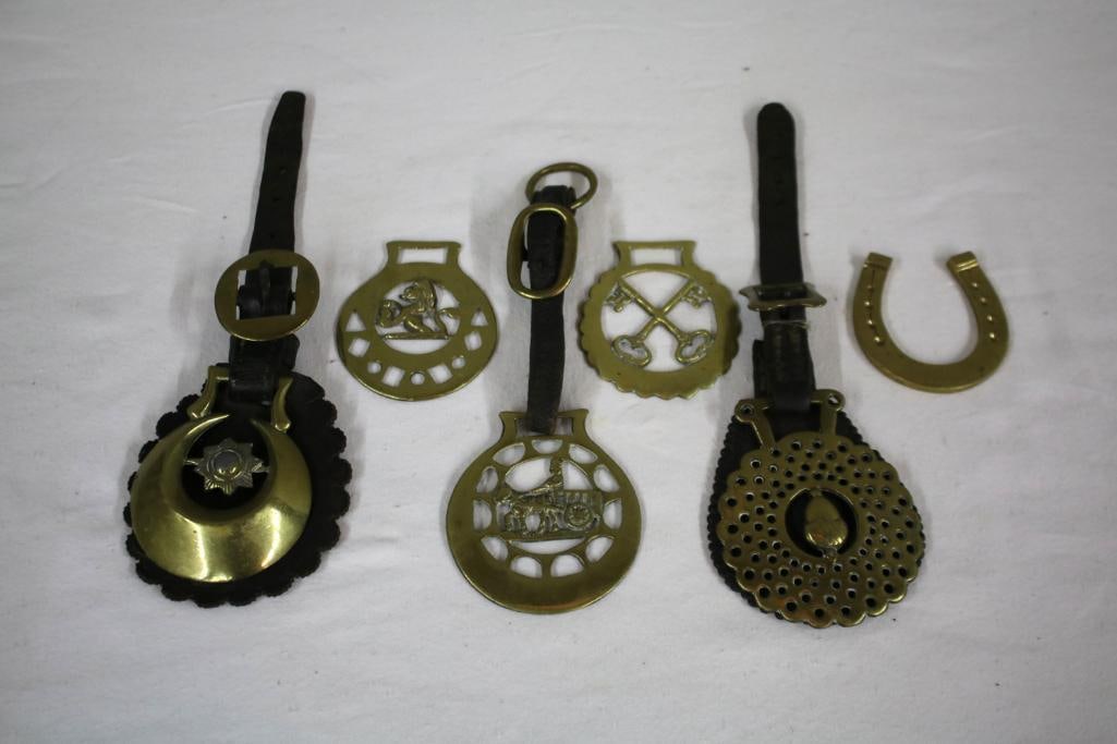 Assorted Horse Brasses: Six horse brasses, three with leather straps. Dimensions: H 1 x W 4 x D 3 inchesNOTE: Good