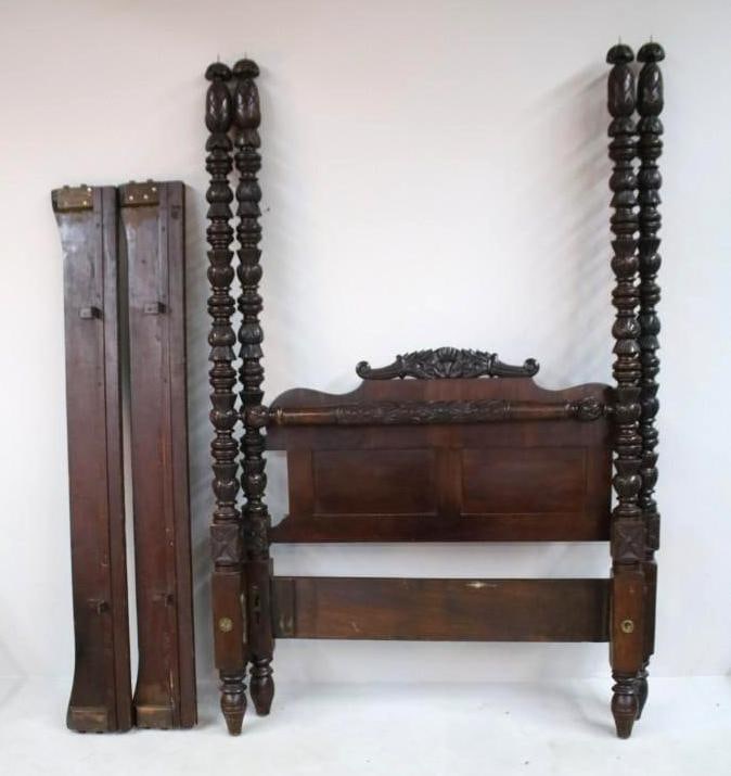 Mahogany Four Poster Bed: A mahogany bedstead, possibly a queen size but might need a custom mattress, with paneled headboard surmounted by a carved crest rail. The tall turned and ringed posts rising to carved finials, joined