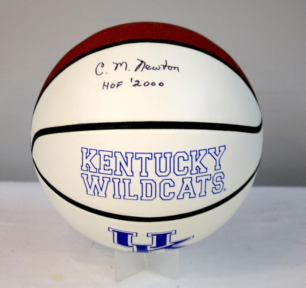 C. M. Newton Signed UK Wildcats Basketball: Kentucky Wildcats basketball signed in black marker by C. M. Newton, longtime University of Kentucky athletic director and College Basketball Hall of Fame inductee, with inscription “HOF 2000.&rdquo