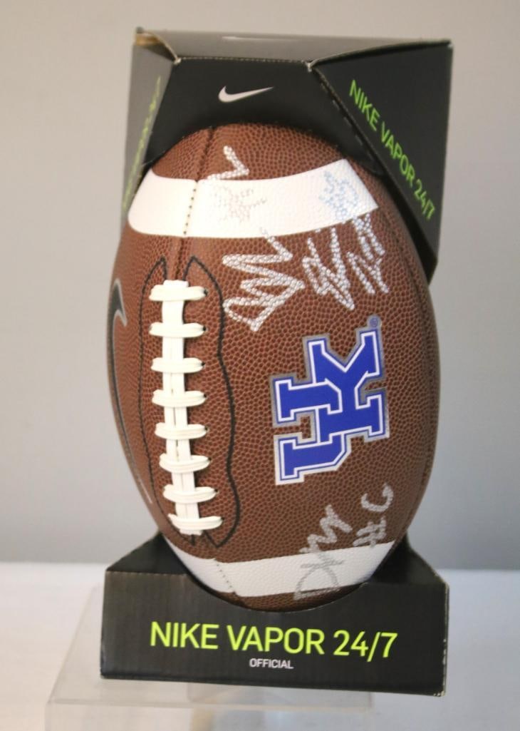 UK Wildcats Football with Unknown Player Signatures: Nike Vapor 24/7 Official football featuring University of Kentucky Wildcats branding, signed in white paint pen by unknown individuals, believed to be associated with the University of Kentucky footba