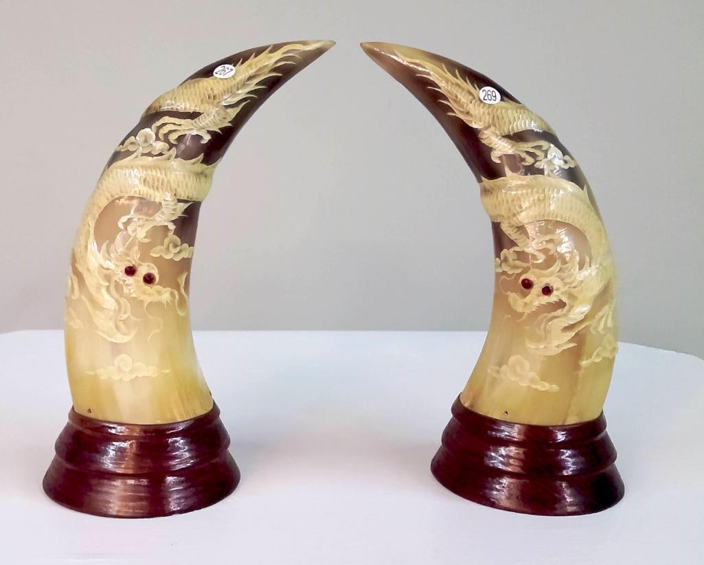 Pair of Carved Dragon Horn Sculptures: Pair of carved horn sculptures depicting dragons emerging among clouds, each carved in relief along the curved form of the horn. The dragons shown with detailed scales and sinuous bodies, the eyes
