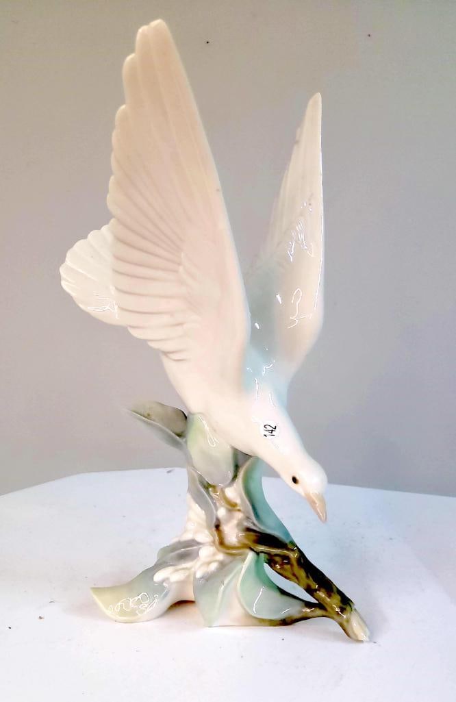 Lladró Porcelain Dove Figure (Flying Form): Glazed porcelain figure depicting a dove in flight with wings fully extended, perched on a stylized branch with soft green and floral elements; typical of Lladró production, Valencia, Spain, late 20t
