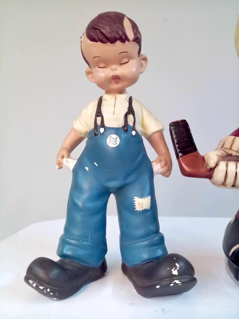 Three Mid-Century Ceramic Child Figures, Including Hockey Player: Group of three mid-20th century ceramic figures depicting children, including a hockey player in red uniform holding a stick, a boy in blue overalls, and a girl in a dress accompanied by a small dog; 
