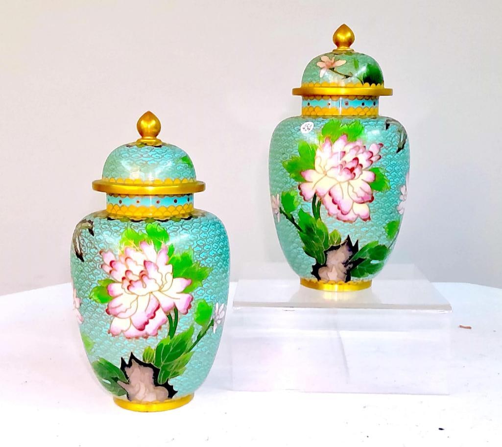 Pair of Chinese Cloisonné Covered Jars with Floral Decoration: A pair of Chinese cloisonné covered jars of baluster form, each decorated with large peony blossoms and foliage reserved on a turquoise ground with repeating cloud pattern. The domed covers are surmo