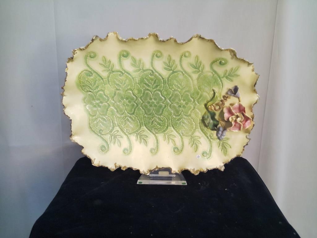 Judy Mayfield Ceramic Serving Platter: This oval ceramic platter, measuring 17 inches by 12 inches, is a signed work by artist Judy Mayfield. The piece is constructed from glazed earthenware and features a scalloped, gilded rim. The centra