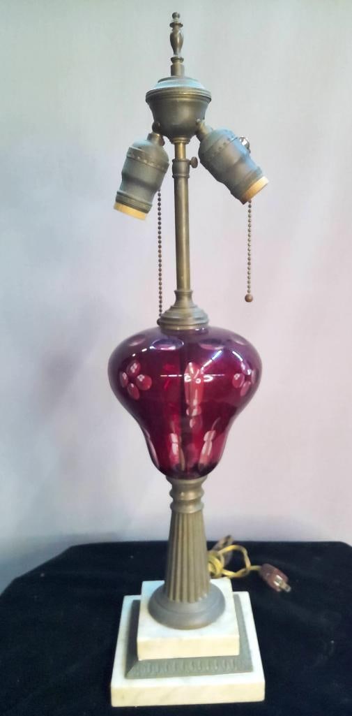 Vintage Ruby Cut-to-Clear Glass and Marble Table Lamp: Table lamp with ruby-colored glass font featuring cut-to-clear floral and geometric designs. The piece includes a fluted metal stem and a tiered marble and brass base with embossed metal trim. The lig