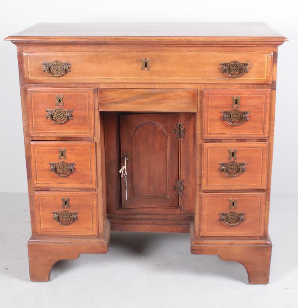 George III Inlaid Cherry Kneehole Desk: English, circa 1800. With a moulded top over a single drawer, the kneehole with a door flanked by three drawers to each side, the whole raised on bracket feet. Dimensions: H 32 x W 33 x D 17.5 inches 
