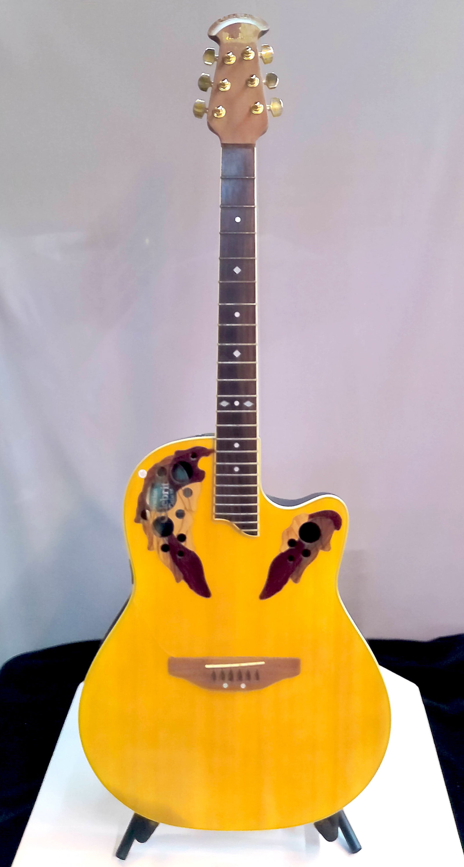Ovation Celebrity Deluxe Acoustic-Electric Guitar: Acoustic-electric guitar by Ovation, Celebrity Deluxe series, model CS257, featuring a multi-soundhole upper bout design with decorative epaulets, natural finish spruce top, and Ovation’s characteri