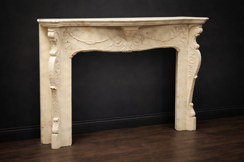 Louis XV Style Painted Faux Marble Mantel: The form follows Rococo revival designs of the Louis XV period. The shaped shelf above a molded frieze carved with scrolling foliage and swag ornament, centered by a stylized shell motif, the uprights