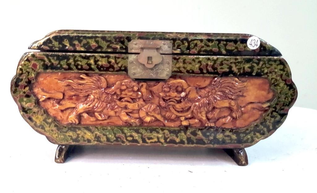 Orientalist Style Lacquered Jewelry Casket with Figural Relief Panel: Rectangular lidded casket raised on short bracket feet, decorated in a mottled green and black lacquer-style finish. The front panel features a molded relief of opposing mythical beasts (likely foo li