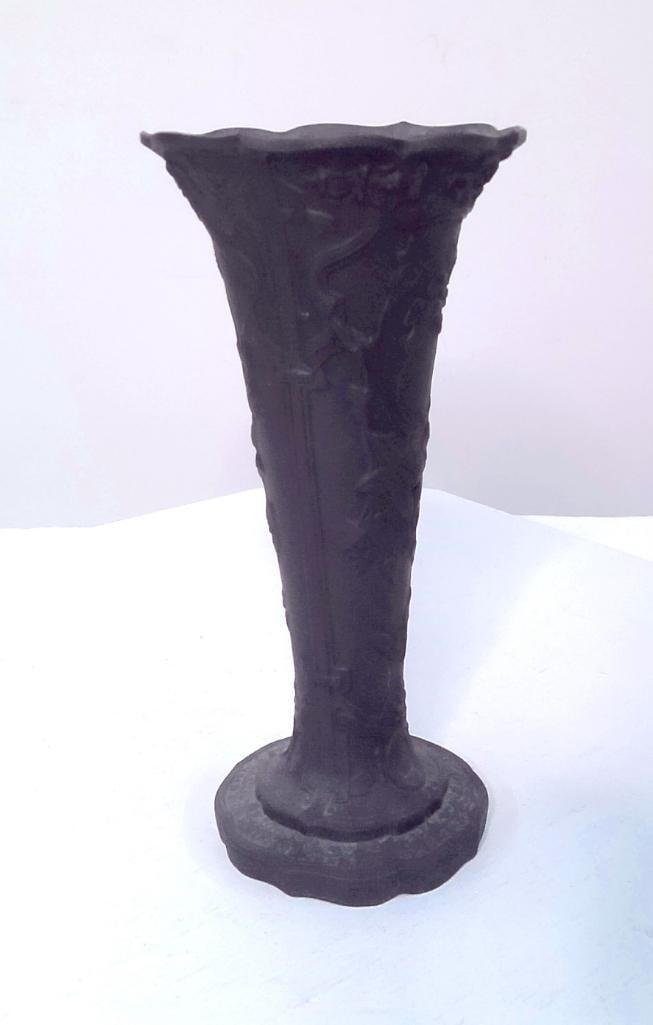 Wedgwood Black Basalt Art Nouveau Vase: England, circa 1900. Trumpet-form black basalt vase with molded Art Nouveau decoration of flowing floral and foliate motifs in relief, rising from a shaped foot to a scalloped rim. Impressed WEDGWOOD 