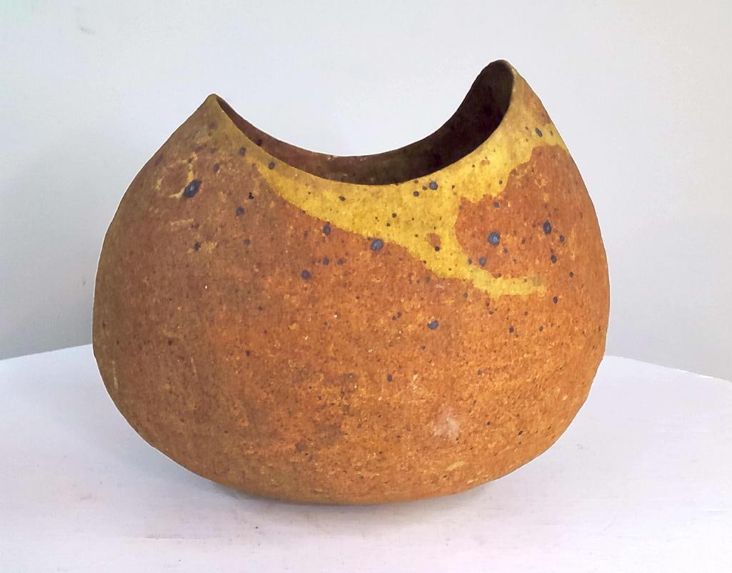 Organic Modern Studio Pottery Pod Vessel: Executed in stoneware and finished in variegated ochre, amber, and iron-speckled glazes, the vessel exhibits an organic sculptural silhouette inspired by natural seed pods and weathered forms. The ung