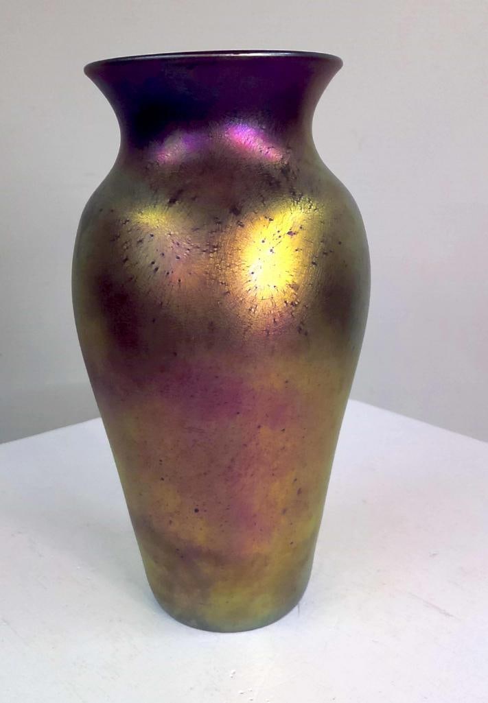 Contemporary Studio Art Glass Iridescent Vase: Hand-blown studio art glass vase of baluster form with broad flared rim, decorated with a metallic iridescent finish displaying gold, magenta, violet and green highlights. Wheel-engraved inscription t