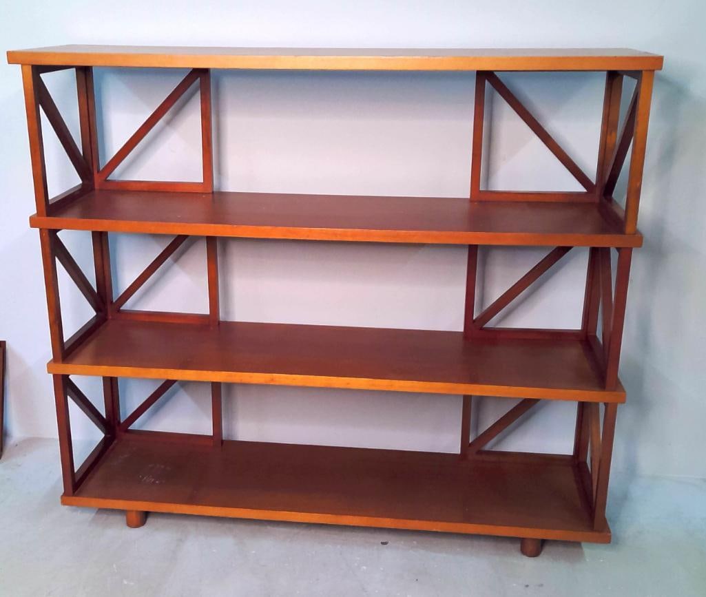 Contemporary Cherry-Finished Open Bookcase: Contemporary open bookcase featuring four fixed shelves within a rectilinear frame, accented by decorative X-form side supports and raised on turned feet. Finished in a warm cherry-toned stain. Dimens