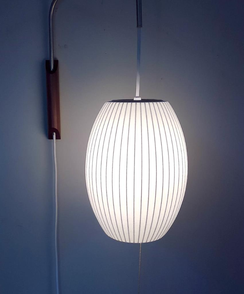 Herman Miller Nelson Cigar Bubble Wall Sconce: George Nelson (1908–1986). Wall-mounted "Cigar" Bubble lamp designed by George Nelson for Herman Miller. Features a ribbed white polymer shade mounted on a brushed metal support arm with wal