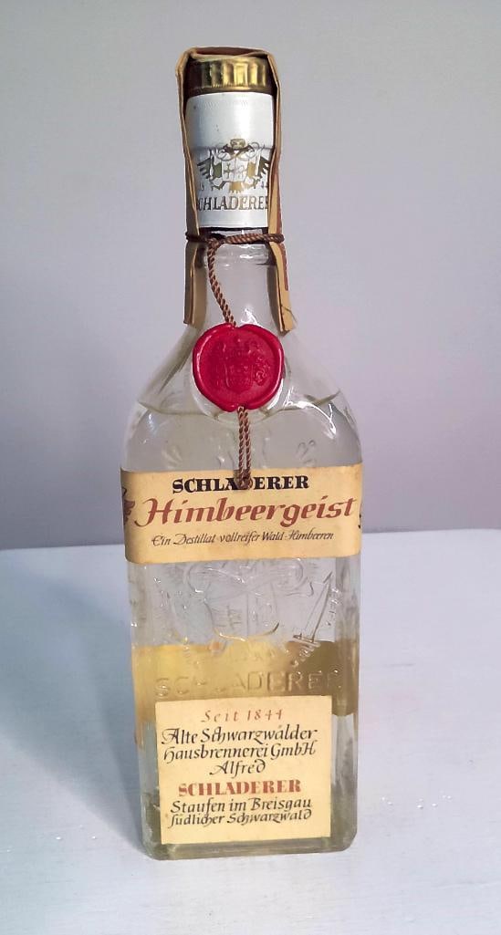 Schladerer Himbeergeist Raspberry Brandy, Square Bottle: Schladerer Himbeergeist Raspberry Brandy, Square Bottle Clear glass square-form embossed bottle of Schladerer Himbeergeist ("Ein Destillat vollreifer Wald-Himbeeren" — a distillate of fully 
